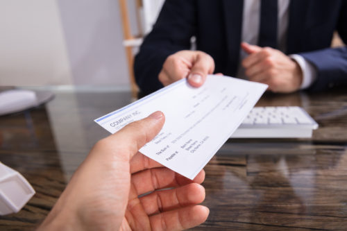 Man receiving a check from a man in a suit