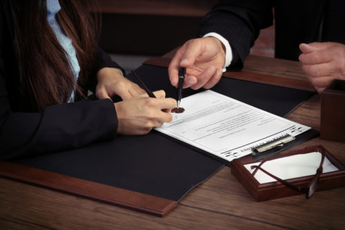 Man and woman signing legal paperwork