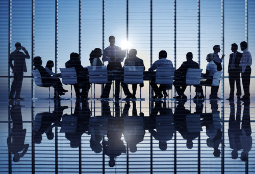 Professionals sitting around a long table at a meeting