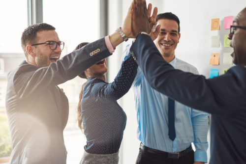 Young professionals smiling and high-fiving