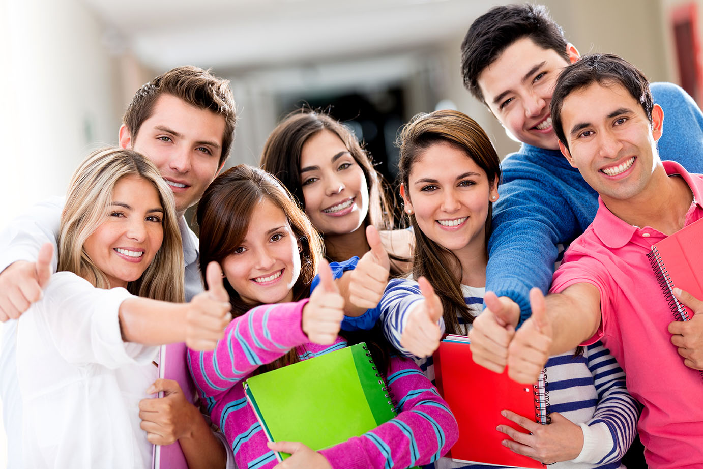 Young group of people smiling and giving us a thumbs up