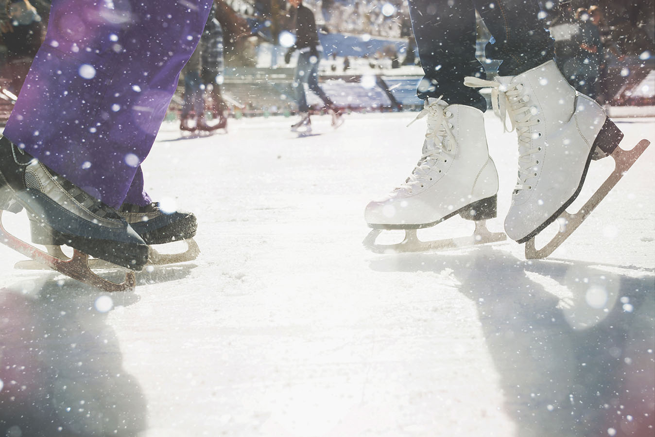 Close up of ice skates on the ice with snow