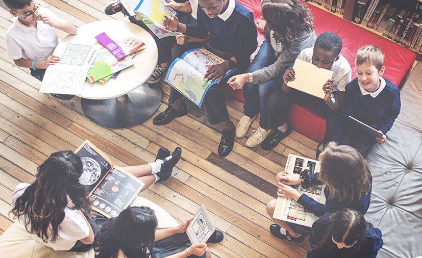 Group that is diverse sitting around on couches with books and papers out