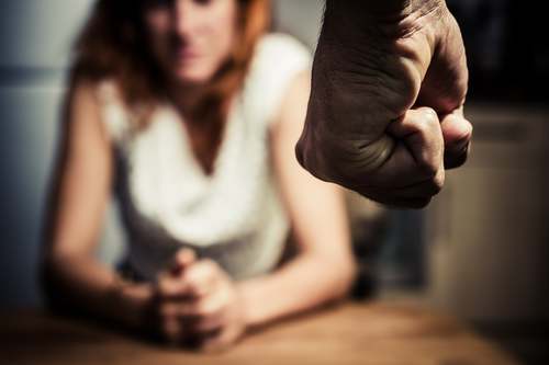 Woman looking scared as man approached her with fist clenched