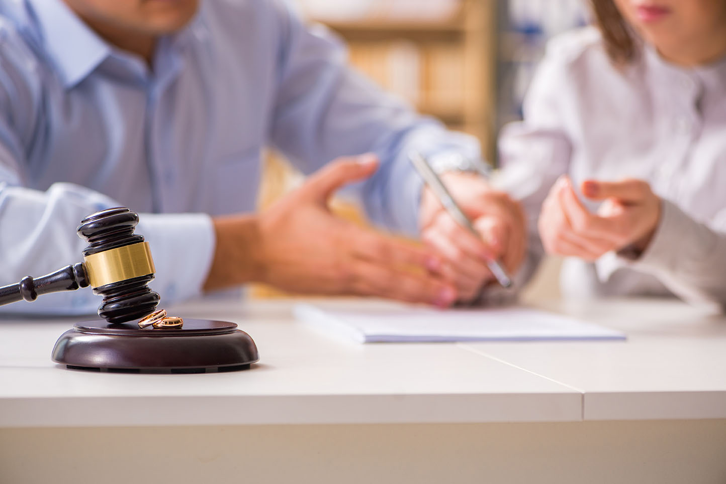 Man signing legal paperwork with gavel on the table
