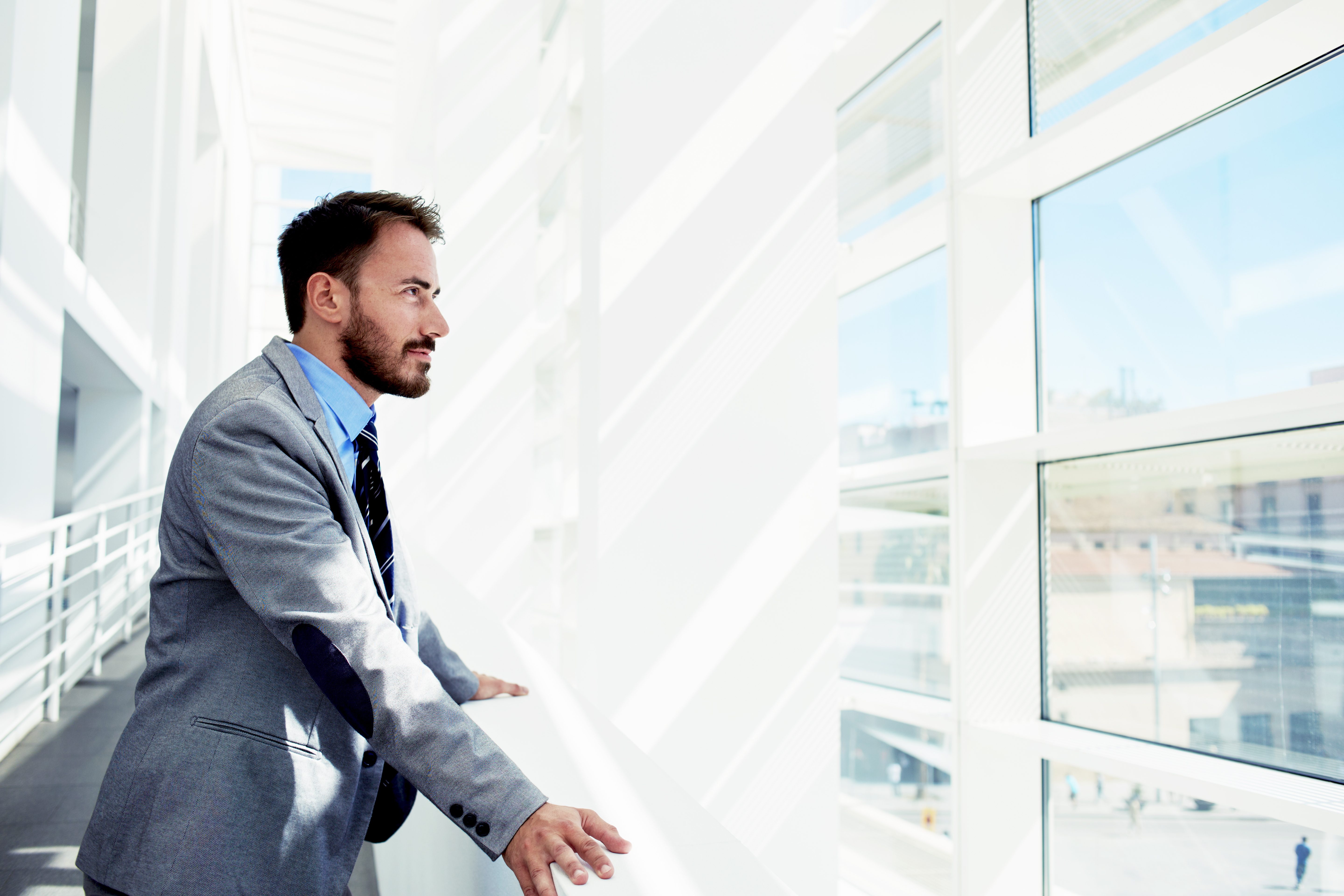 Professionally dressed young man looking out a window