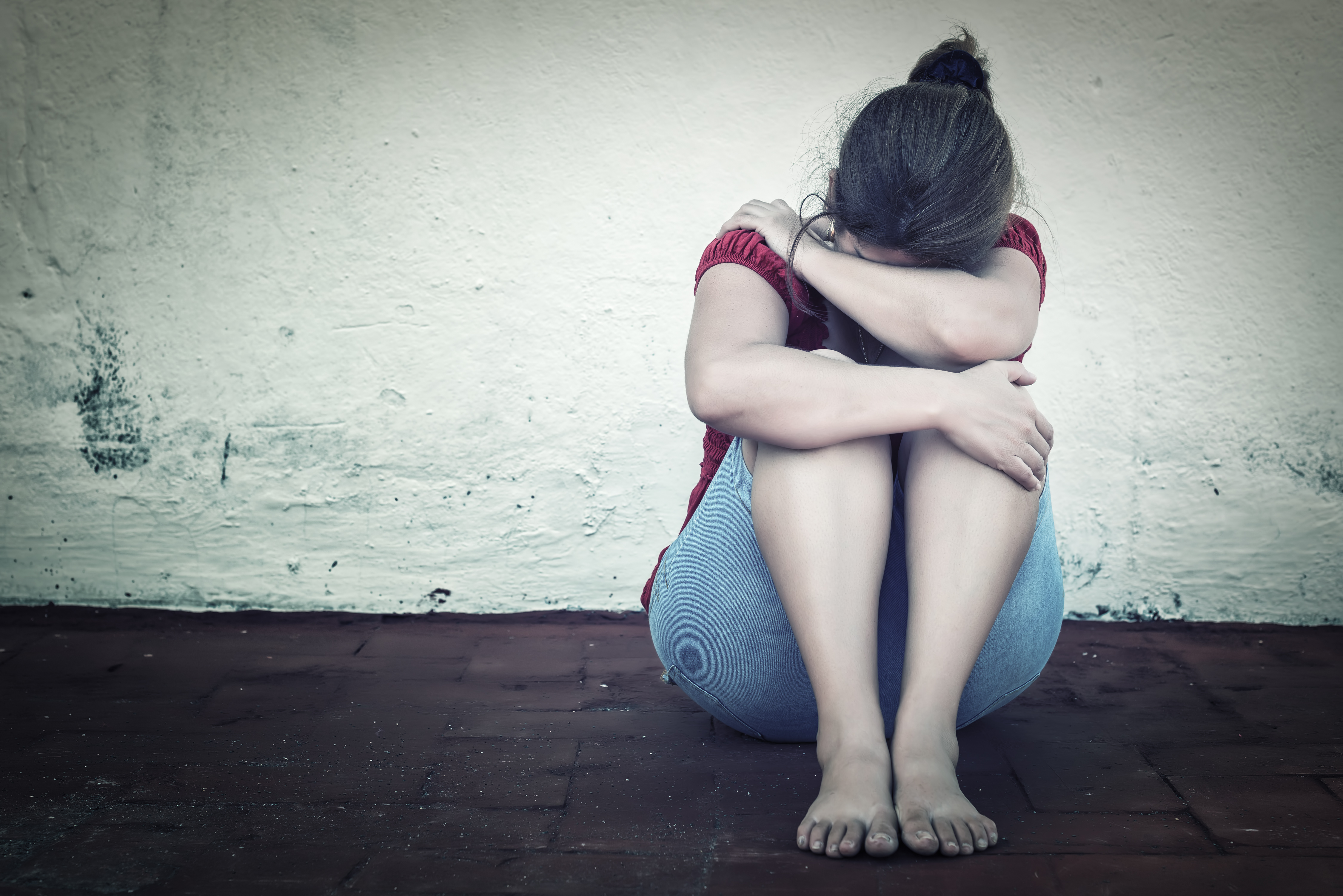 Sad woman with sitting with her head down 