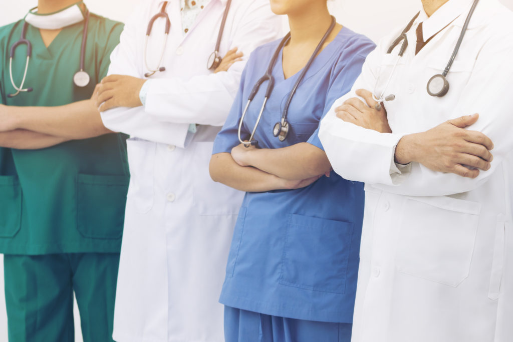 Group of nurses and doctors standing with arms crossed