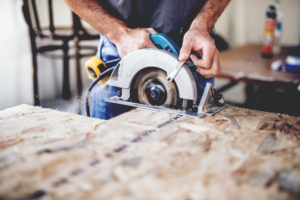 Man using saw on wood